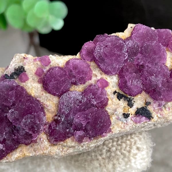 Raspberry strawberry-fluorite balls on tall tan sliver from Henan, China, reverse side