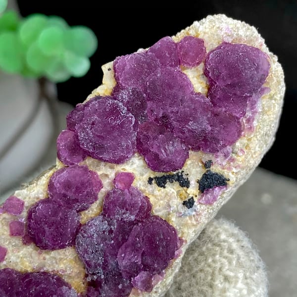 Raspberry strawberry-fluorite balls on tall tan sliver from Henan, China, top view