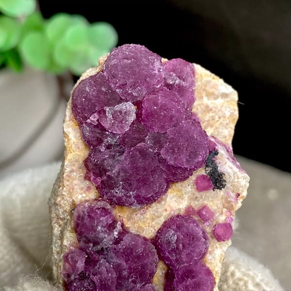Raspberry strawberry-fluorite balls on tall tan sliver from Henan, China, overall view