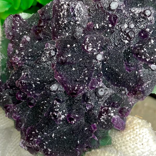 Dark green fluorite octahedra with purple edges and sparkling coating from Zhejiang, China, detail of the matrix contact