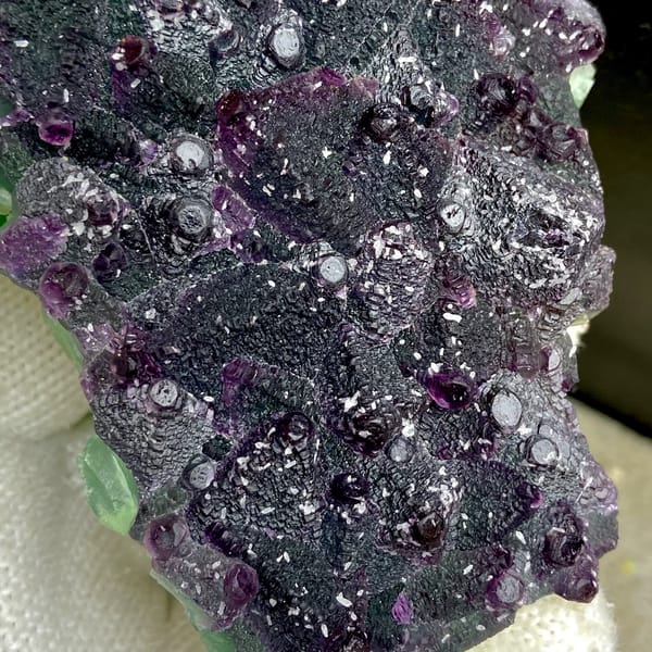 Dark green fluorite octahedra with purple edges and sparkling coating from Zhejiang, China, close-up of terminations