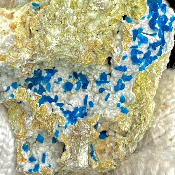 Electric-blue platy veszelyite on tan matrix from Yunnan, China, close-up of the crystal faces