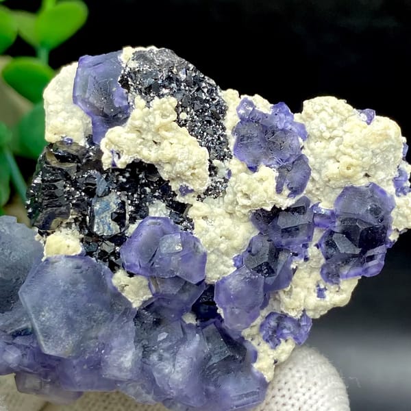 Frosted lavender phantom fluorite with black crystals and cream druse from Inner Mongolia, detail of the matrix contact
