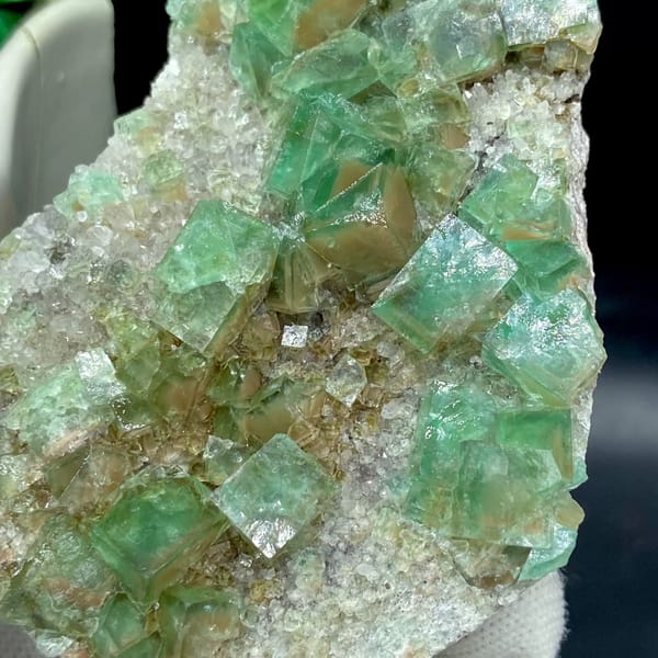 Glassy sea-green fluorite cubes on pale matrix plate from Hebei, China, close-up of the crystal faces