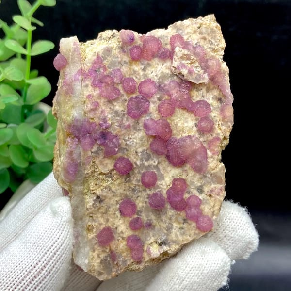Raspberry strawberry-fluorite balls on tall tan plate from Henan, China, close-up of terminations