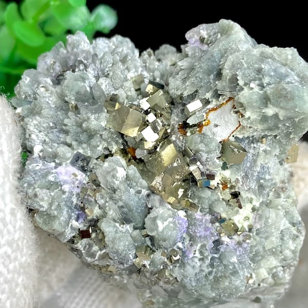 Brassy pyrite cubes on pale green quartz from Shangbao, Hunan, China, close-up of the crystal faces