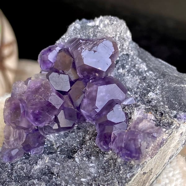 Transparent violet fluorite cubes on dark grey block from Fujian, China, detail of the matrix contact