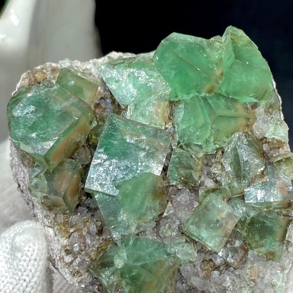 Transparent green fluorite cubes on sparkling quartz from Hebei, China, top view