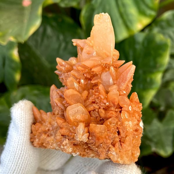 Orange calcite cluster of stacked pointed crystals from Yunnan, China, close-up of the crystal faces