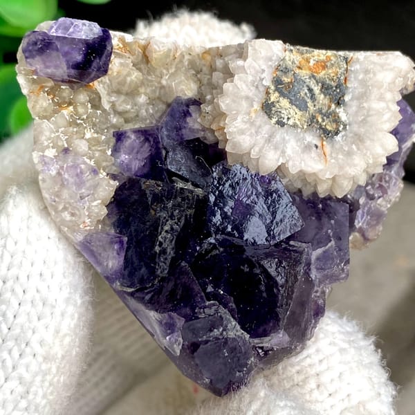 Deep purple fluorite cubes above white bladed calcite from Fujian, China, detail of the matrix contact