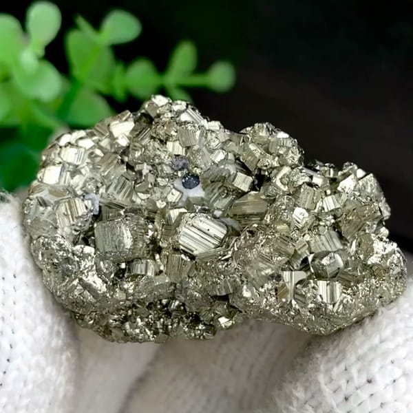 Pyrite cube cluster with black marmatite from Peru, held in gloved hand