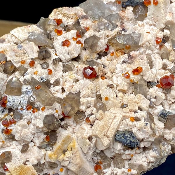 Bar of feldspar dotted with Fanta-orange spessartine and smoky quartz from Yunxiao, Fujian, China, top view