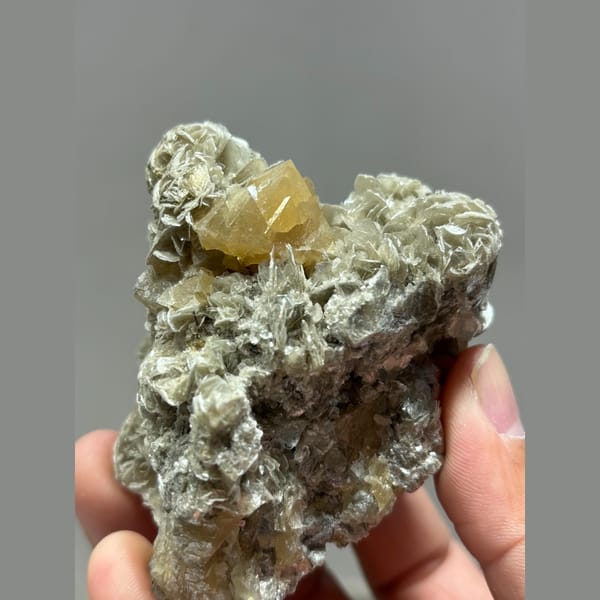 Golden-orange scheelite crystal on silvery mica from Xuebaoding, Sichuan — alternate view
