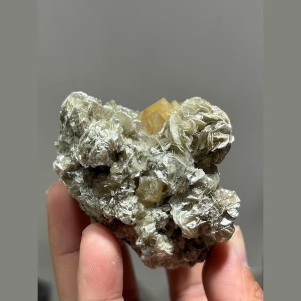 Golden-orange scheelite crystal on silvery mica from Xuebaoding, Sichuan — alternate view