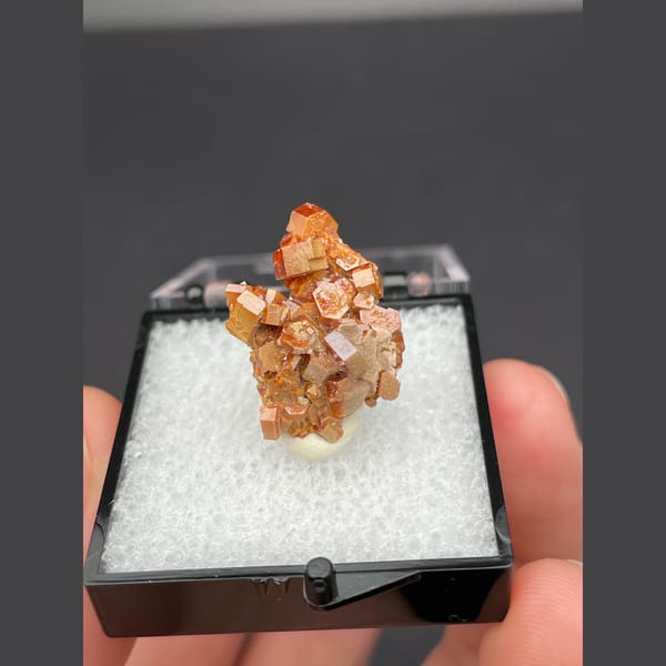 Small cluster of glossy red-orange vanadinite crystals from Morocco — complete view