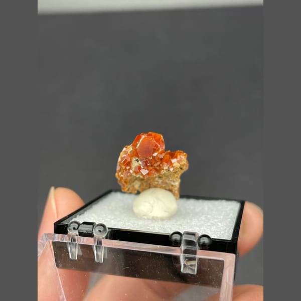 Small cluster of glossy red-orange vanadinite crystals from Morocco — alternate view