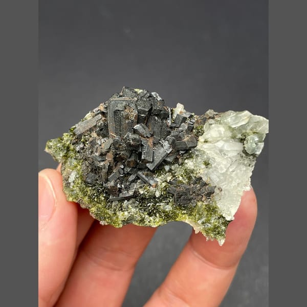 Dark bladed crystals with green epidote and quartz from Zhaotong — alternate view