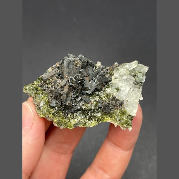 Dark bladed crystals with green epidote and quartz from Zhaotong — detail view