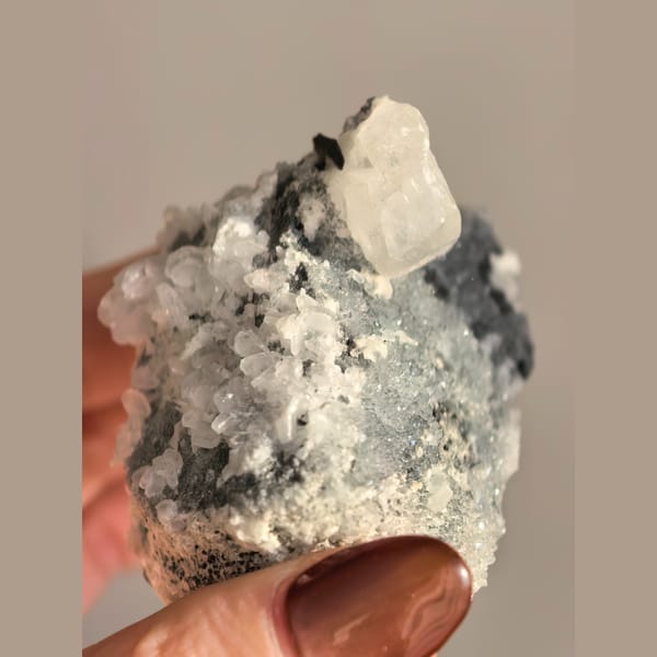 Single quartz crystal on matrix with small biscuit calcite crystals — alternate view