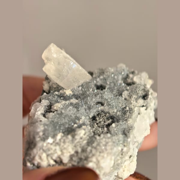 Single quartz crystal on matrix with small biscuit calcite crystals — alternate view