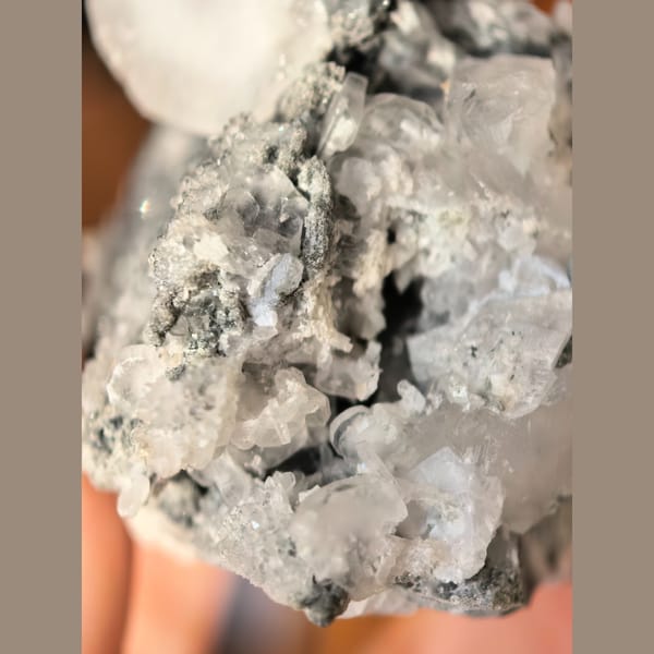 Single quartz crystal on matrix with small biscuit calcite crystals — detail view