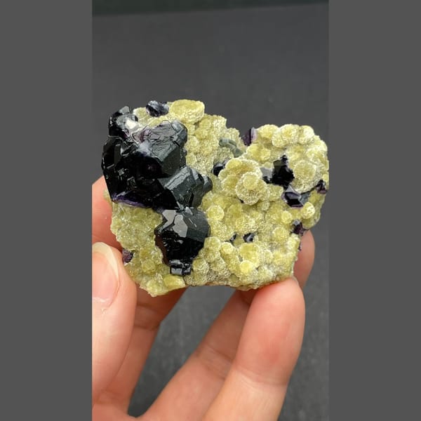 Dark apatite with purple fluorite on yellow-green mica from Inner Mongolia — complete view