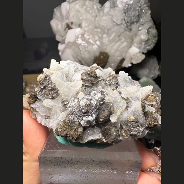 Dogtooth calcite with sugary quartz and a dark mineral — detail view