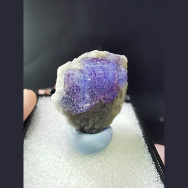 Blue fluorite with purple flower-like etch patterns — complete view