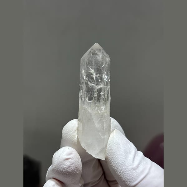 Slender clear quartz crystal from Xuebaoding, Sichuan — complete view