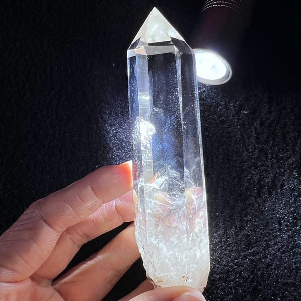 Tall clear quartz point with white phantoms and blue needle inclusions — complete view