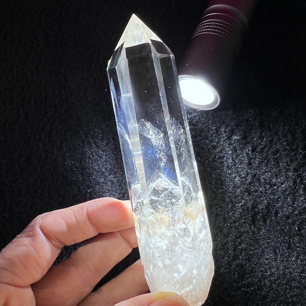 Tall clear quartz point with white phantoms and blue needle inclusions — alternate view
