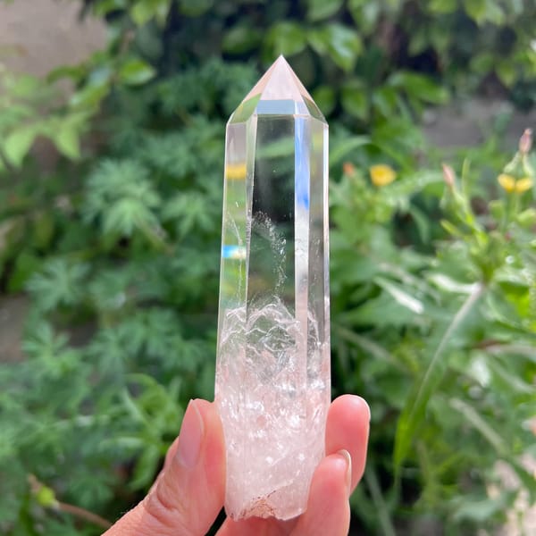 Tall clear quartz point with white phantoms and blue needle inclusions — alternate view