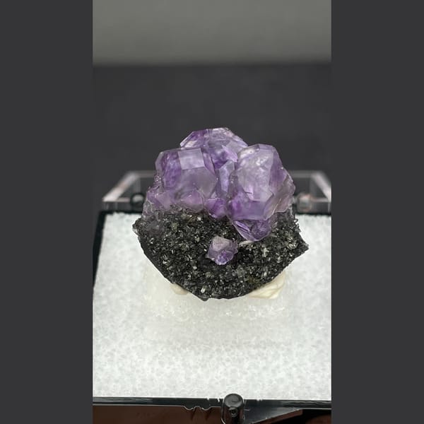 Small violet tanzanite fluorite on dark matrix from Fujian — complete view