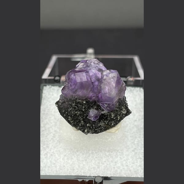 Small violet tanzanite fluorite on dark matrix from Fujian — alternate view