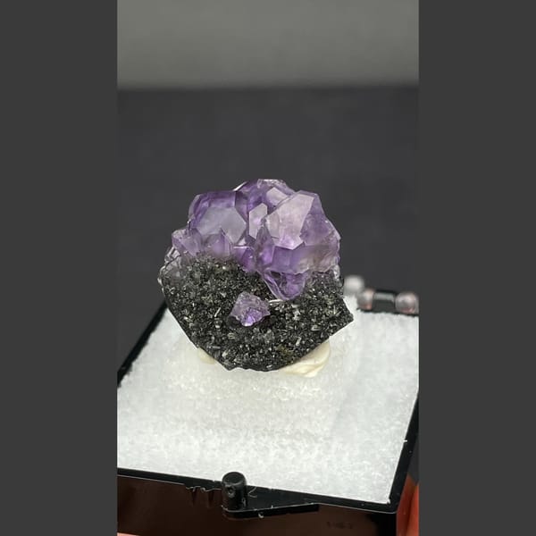 Small violet tanzanite fluorite on dark matrix from Fujian — detail view