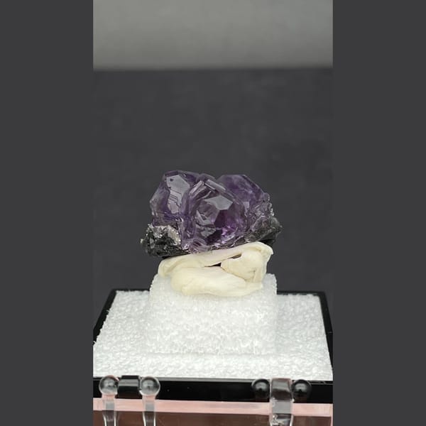 Small violet tanzanite fluorite on dark matrix from Fujian — detail view