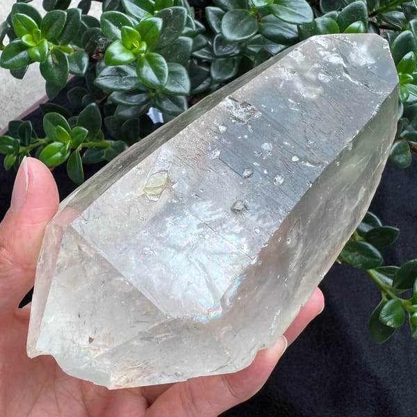 Bright striated clear quartz crystal with rainbows from Brazil — detail view