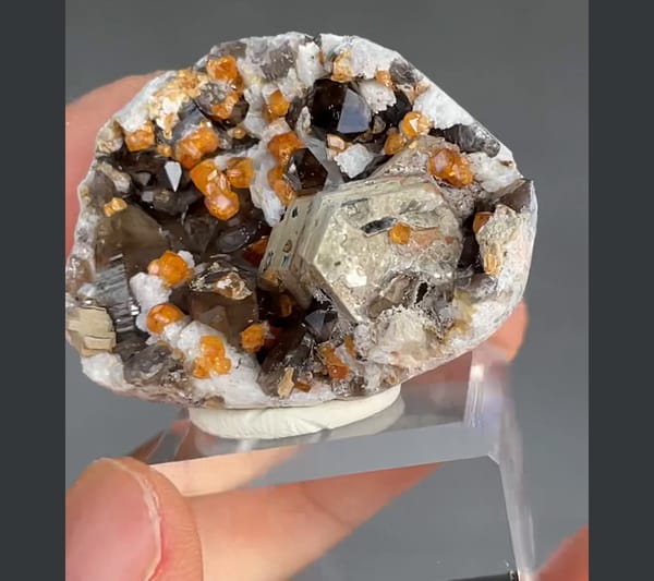 Complete right oblique view of the same Tongbei spessartine and smoky quartz specimen