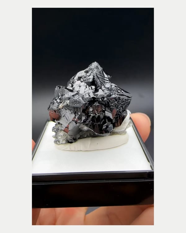 Complete left side view of stepped black cassiterite