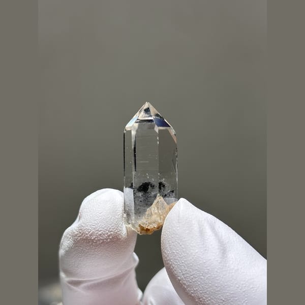 Small clear window quartz floater with dark inclusions from Jinkouhe — alternate view