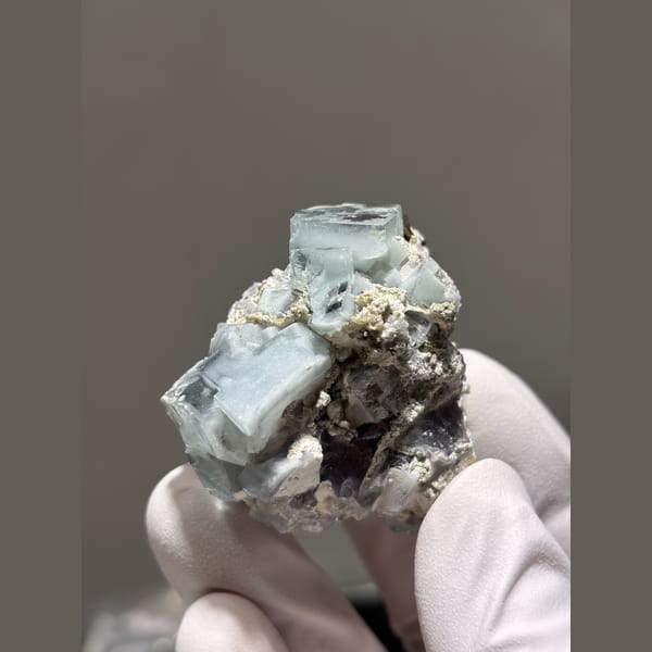 Pale blue porcelain-lustre fluorite cubes with mica from Yaogangxian — detail view