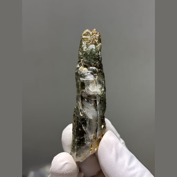 Long quartz crystal coated with green chlorite from Tibet — complete view
