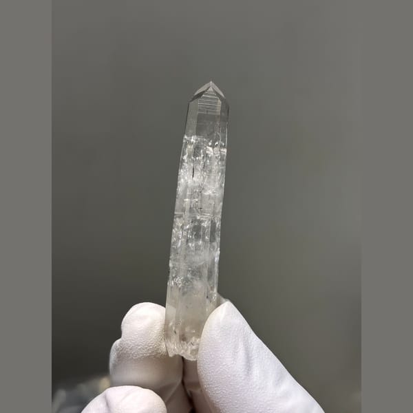 Slender clear quartz point from Jinkouhe — complete view