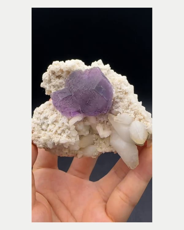 Complete low side view of fluorite on broad calcite matrix