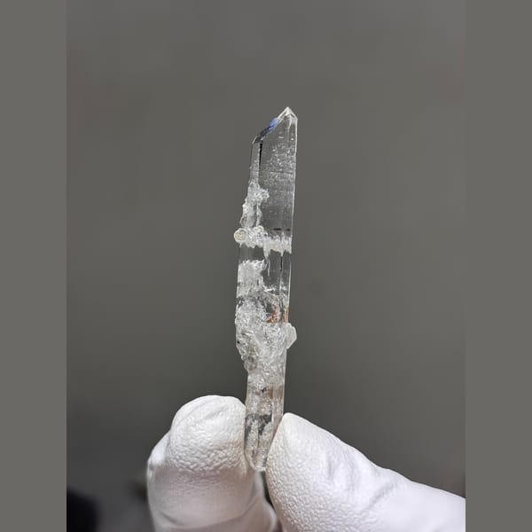 Slender clear double-terminated quartz with scheelite and mica from Xuebaoding — alternate view