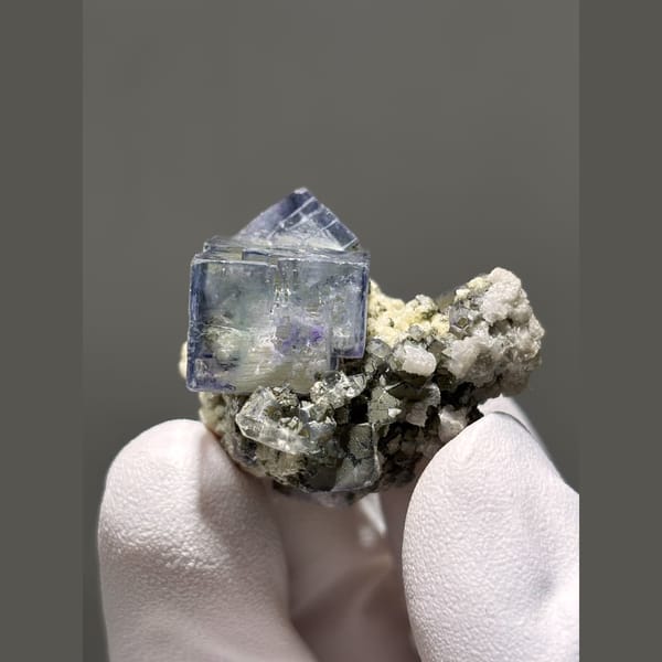 Glassy blue-purple fluorite cube on matrix from Yaogangxian, Hunan — complete view