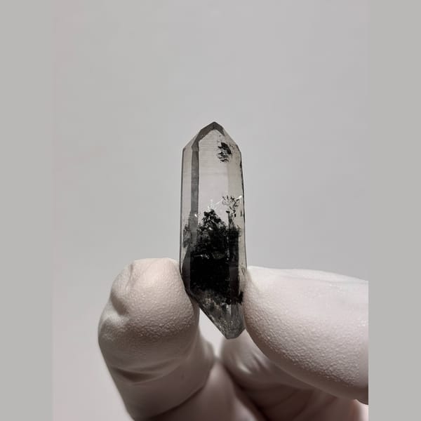 Slim clear quartz floater with black inclusions from Jinkouhe — alternate view