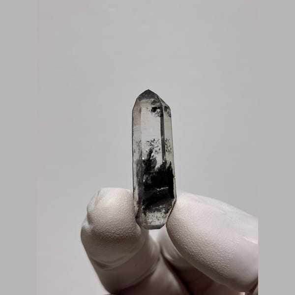 Slim clear quartz floater with black inclusions from Jinkouhe — alternate view