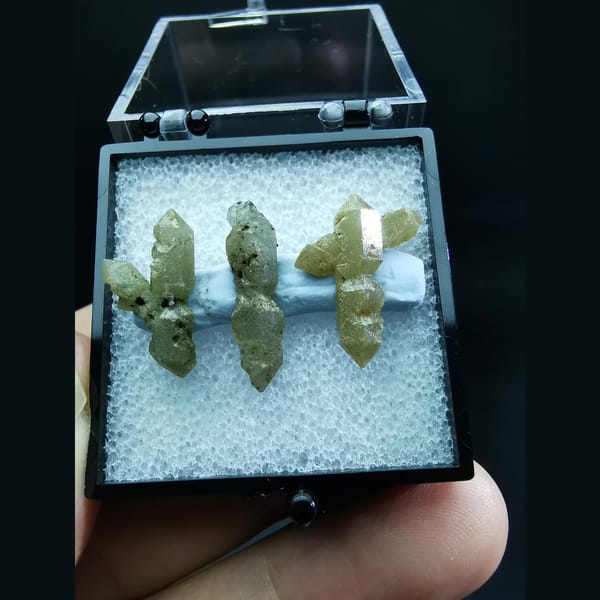 Three double-terminated green quartz crystals — complete view