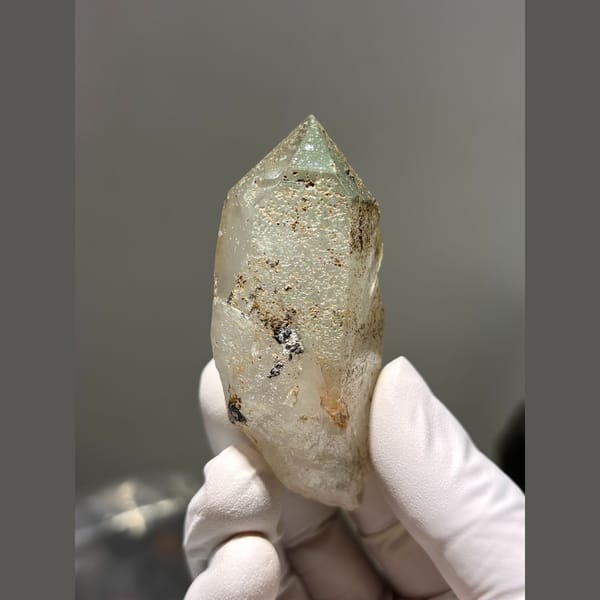 Chunky quartz point with green and rusty inclusions from Tibet — complete view